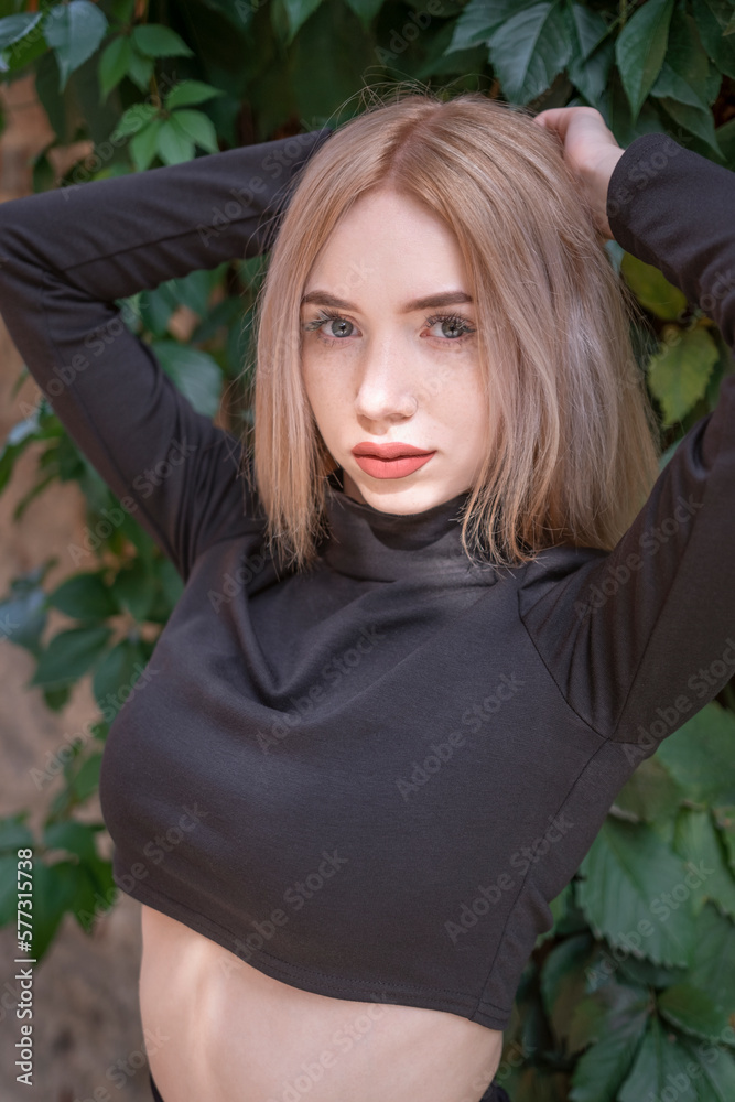 Teenage Girl With Blonde Hair And Red Lips Wears Short Black Turtleneck 