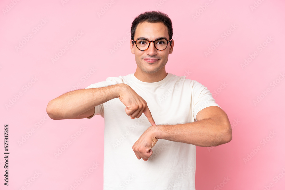 Young caucasian man isolated on pink background making the gesture of being late Young caucasian man isolated on pink background making the gesture of being late