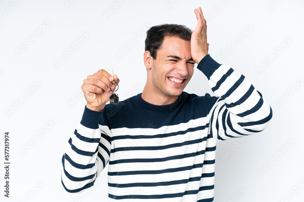 Fototapeta premium Young caucasian man holding home keys isolated on white background has realized something and intending the solution