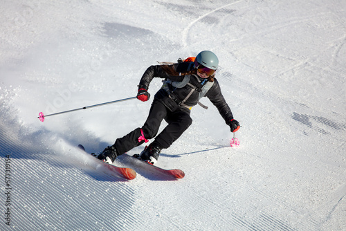 Girl On the Ski. Active winter holidays, skiing downhill in sunny day. Woman skier