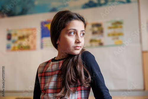 Alunna vestita con un vestito a quadri in un aula di una scuola photo