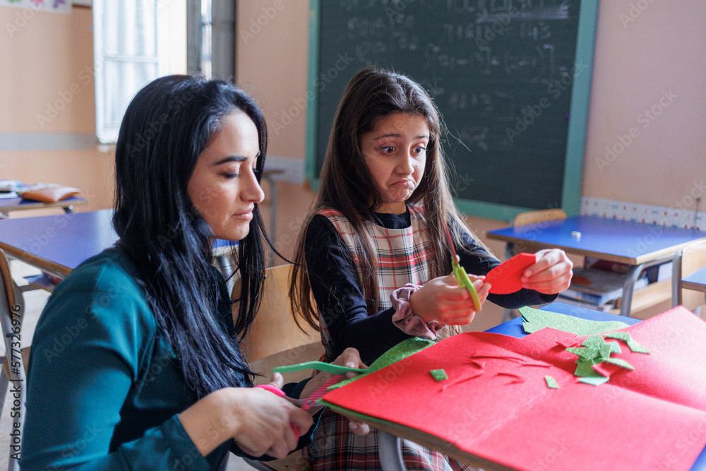 Fototapeta premium Una maestra svolge delle attività educative con un alunna a scuola