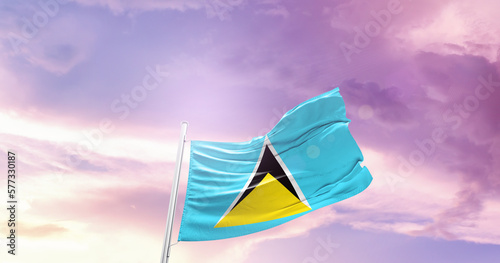 Waving Flag of Saint Lucia in Blue Sky. The symbol of the state on wavy cotton fabric.