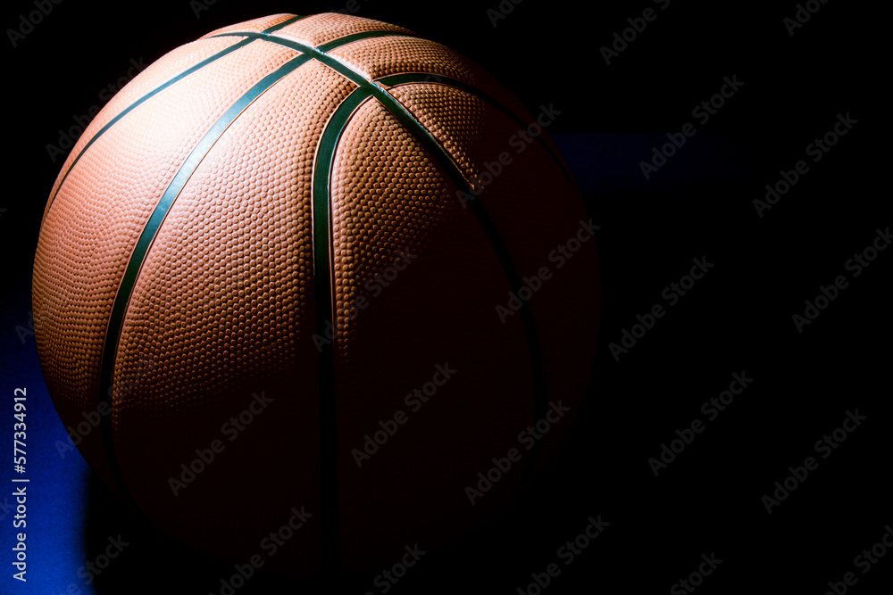 Obraz premium Basketball in Partial Shade on a Blue Surface