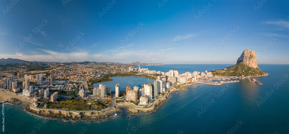 Drone panoramic view of high-rise buildings in Calpe city and Les Salines salt lake.