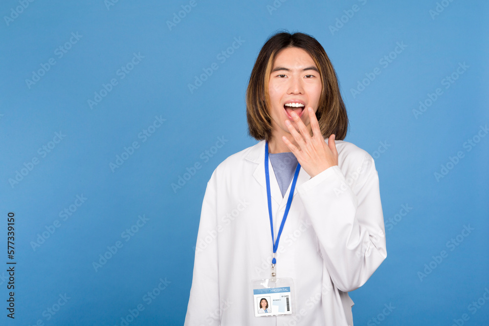 Young Japanese Man in White Lab Coat with Surprised Expression, Hand on Mouth, Studio Portrait Young Japanese Man in White Lab Coat with Surprised Expression, Hand on Mouth, Studio Portrait