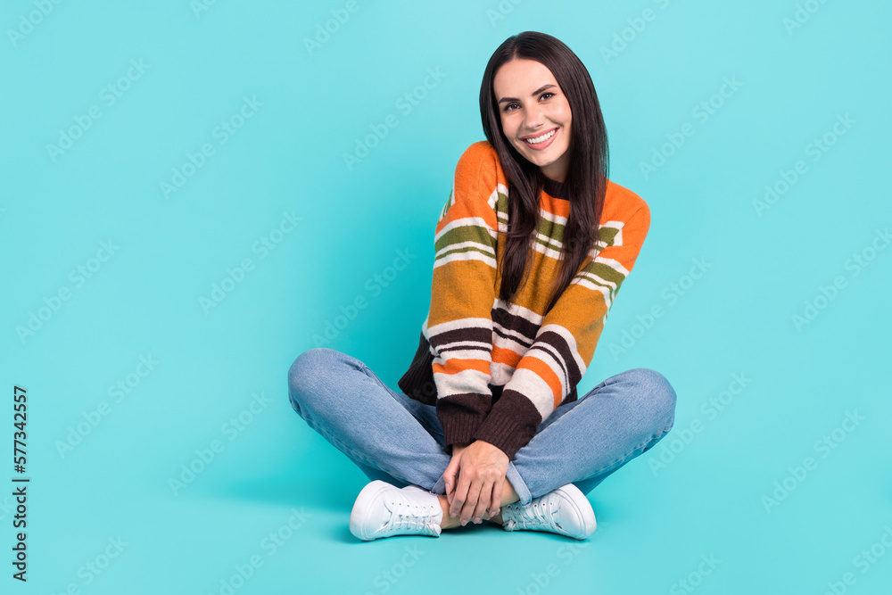 Full length photo of dreamy adorable woman wear sweater sitting legs crossed empty space isolated turquoise color background Full length photo of dreamy adorable woman wear sweater sitting legs crossed empty space isolated turquoise color background