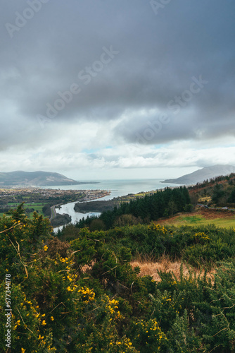 Grey cloudy sky, with rolling green hills and vegetation, Slieve Gullion, Co. Armagh,  Ring of Gullion, Northern Ireland, showing wall, river and ocean photo