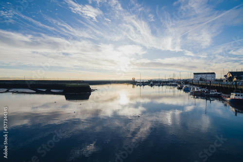 Carrickfergus, Northern Ireland, wide angle lens with sunrise, blue sky, water reflections and horizon, close to Carrickfergus castle