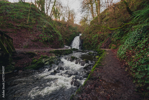 The beautiful Glenoe waterfall nestling in the glens of Antrim, Northern Ireland, with green moss and trees photo