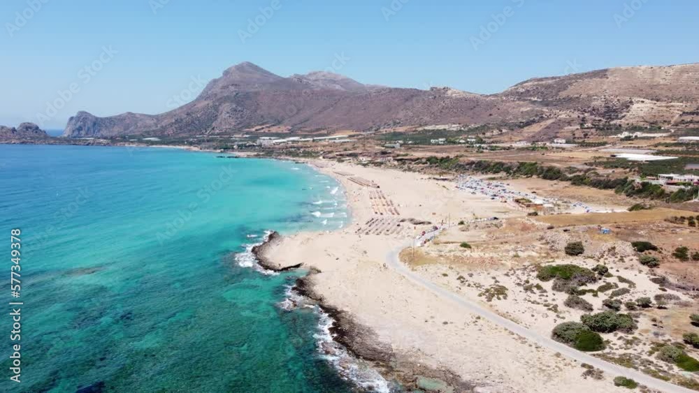 Aerial view orbiting idyllic Falassarna beach, Crete with tourists sunbathing and swimming in Azure Aegean sea Aerial view orbiting idyllic Falassarna beach, Crete with tourists sunbathing and swimming in Azure Aegean sea