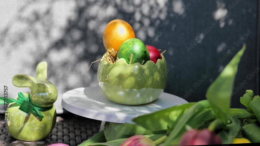 Easter colorful eggs rotate in nest with hey outdoor in sunny warming day.