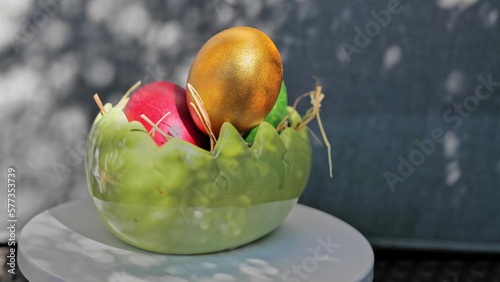 Obraz na płótnie Easter colorful eggs rotate in nest with hey outdoor in sunny warming day. w salonie