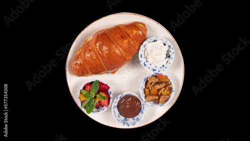Breakfast plate on isolated black background. Croissant