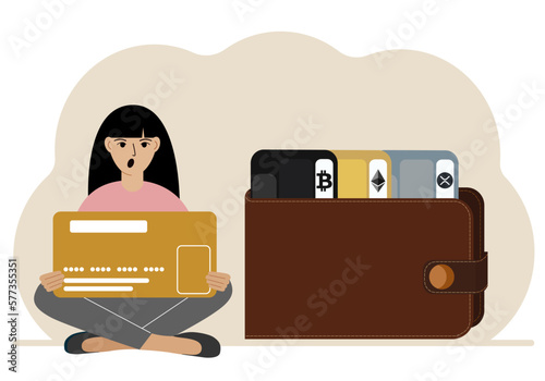 A woman holds a card, next to a wallet with different cards for cryptocurrencies. Internet wallet, digital money transactions, exchange platform, cold wallet or hardware wallet.