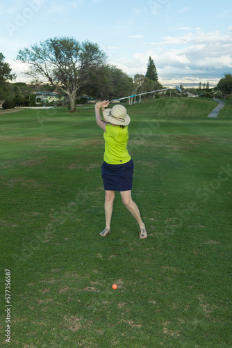 Woman Golfer's Back Swing on a Golf Course Fairway