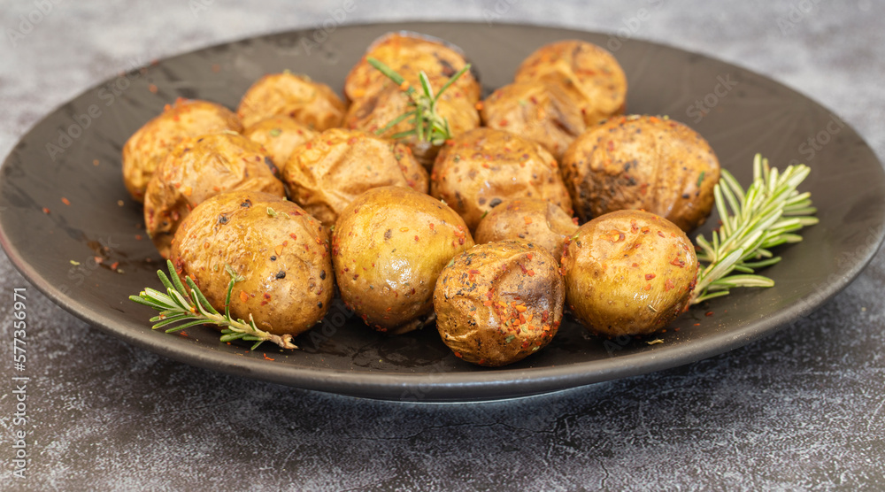 Fried (baked) whole small potatoes with rosemary and salt in a frying pan, ruddy crust, appetizing food Fried (baked) whole small potatoes with rosemary and salt in a frying pan, ruddy crust, appetizing food