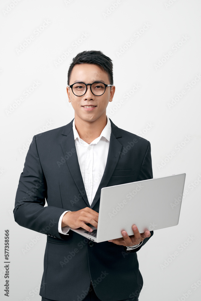Young asian business man standing work on laptop computer to internet online Young asian business man standing work on laptop computer to internet online