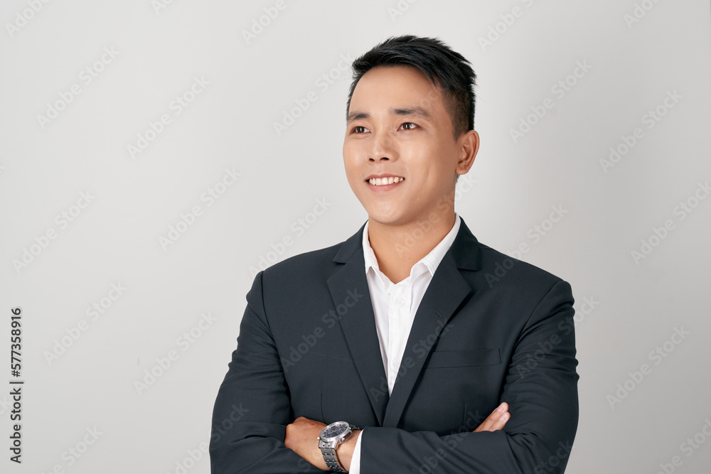Asian businessman standing with his arms crossed and smiling on a white background Asian businessman standing with his arms crossed and smiling on a white background