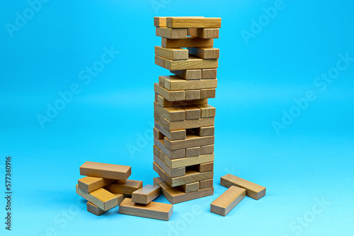 Wooden blocks tower. Building collapse games with family and friends. Leisure time.