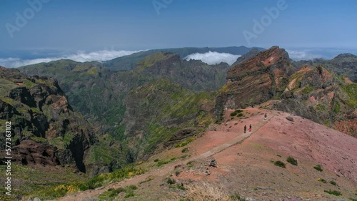 Aerial view over the clouds from slopes of Pico do Arieiro, Madeira, Portugal timelapse. Overview above the fog. Tourists walking on a footpath