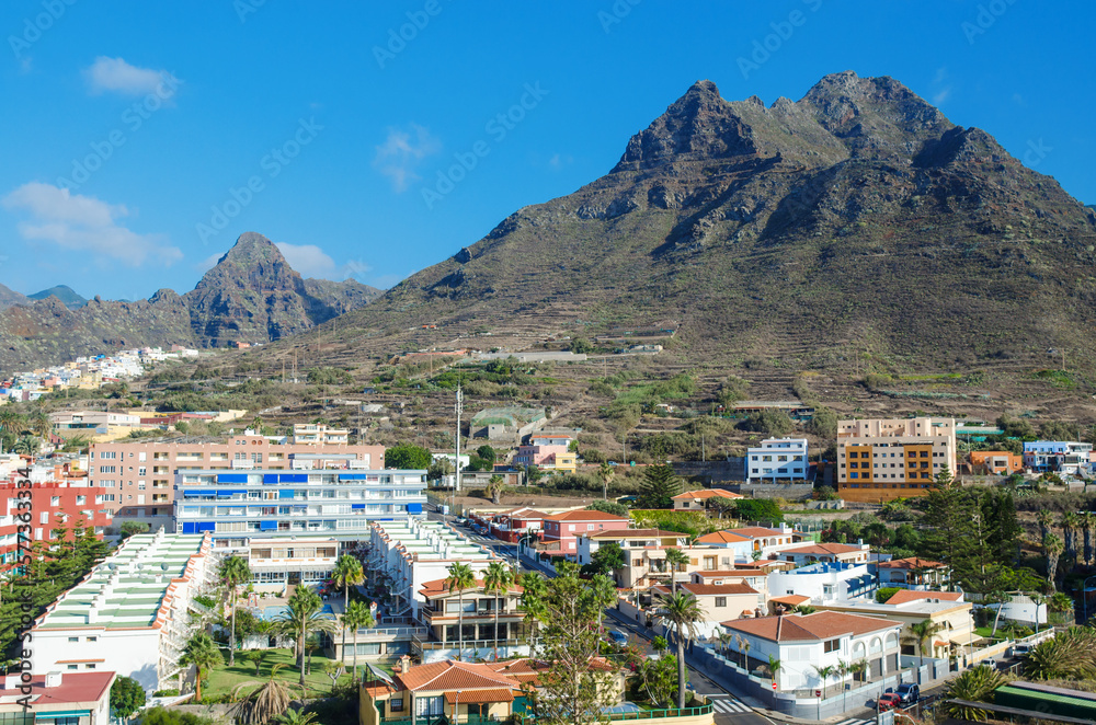 Aerial view of the resort town of Punta del Hidalgo and beautyful mountains in the background. Typical architecture of the North of Tenerife island. Canary islands, Spain