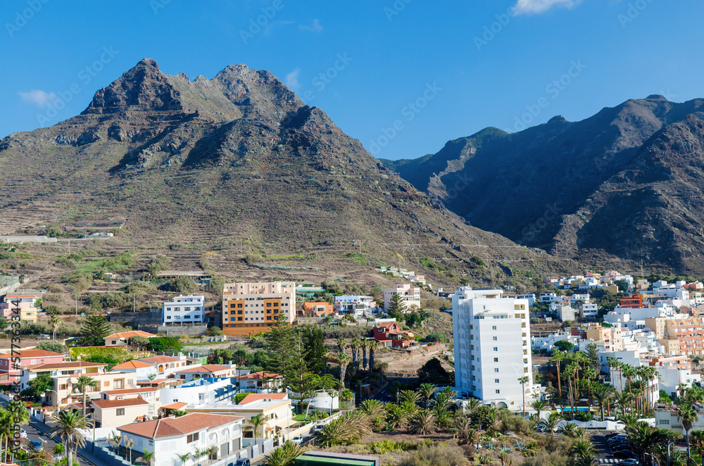Aerial view of the resort town of Punta del Hidalgo and beautyful mountains in the background. Typical architecture of the North of Tenerife island. Canary islands, Spain