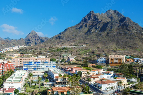 Aerial view of the resort town of Punta del Hidalgo and beautyful mountains in the background. Typical architecture of the North of Tenerife island. Canary islands, Spain © kazmulka