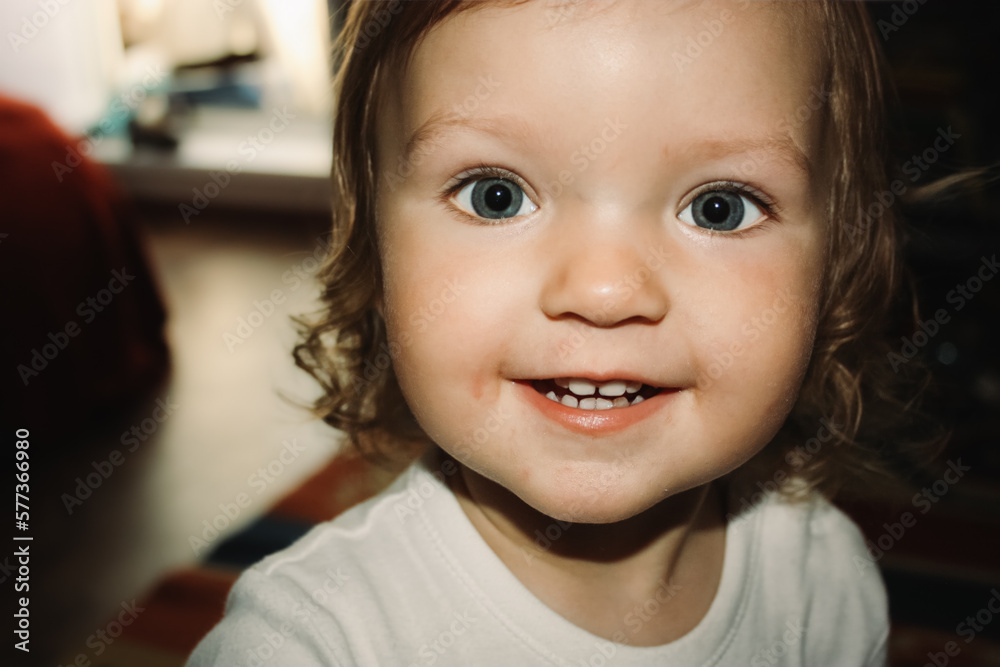 Little blue-eyed girl smiles and looks into the camera. Little blue-eyed girl smiles and looks into the camera.