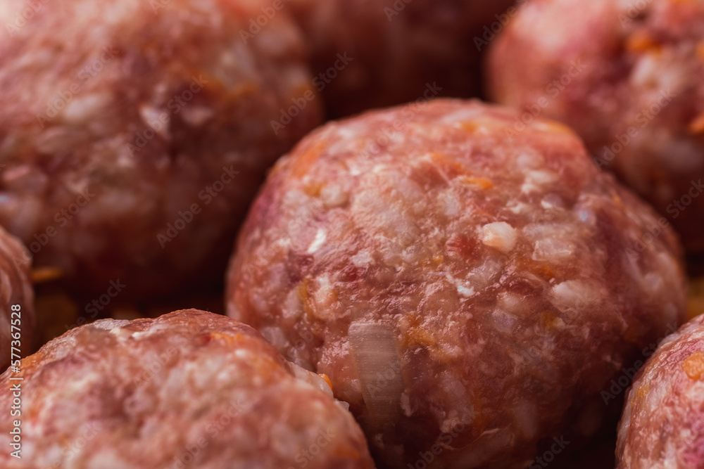 Homemade meatballs with tomato sauce, carrot and spices. Raw ground beef meatballs with rice in a white dish for baking. White marble background. Original way to cook meat Homemade meatballs with tomato sauce, carrot and spices. Raw ground beef meatballs with rice in a white dish for baking. White marble background. Original way to cook meat