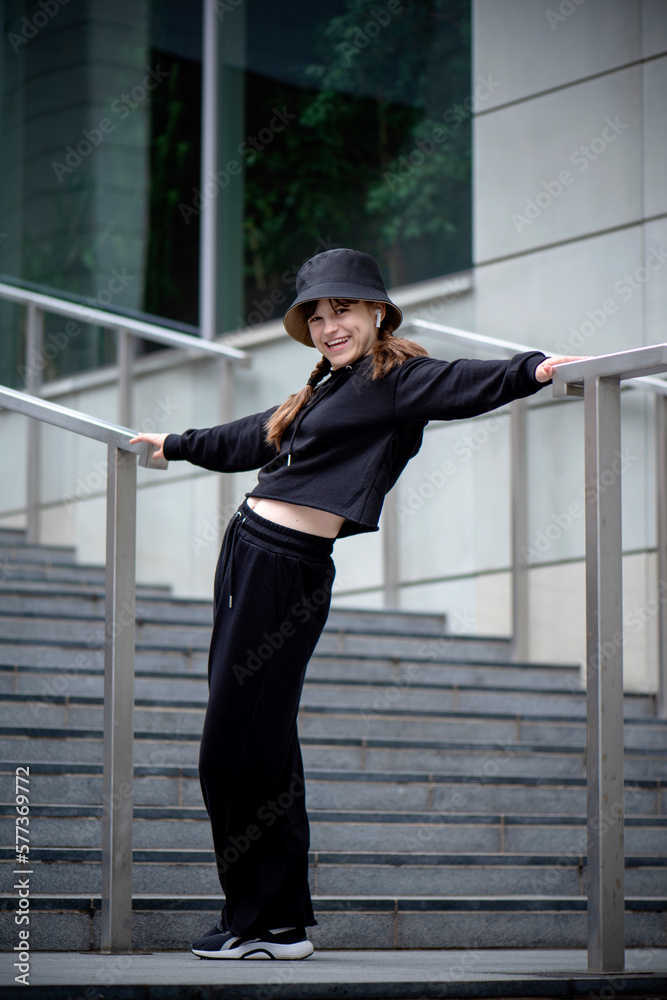 portrait of a girl on a city background, young beautiful woman posing in the park against the backdrop of buildings portrait of a girl on a city background, young beautiful woman posing in the park against the backdrop of buildings