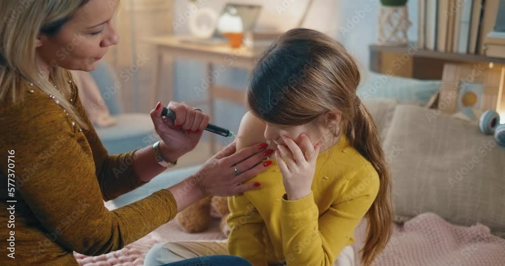Mother gives her daughter a dose of insulin. Mom encourages her daughter by hugging her after receiving her insulin dose at home. Diabetes control Mother gives her daughter a dose of insulin. Mom encourages her daughter by hugging her after receiving her insulin dose at home. Diabetes control