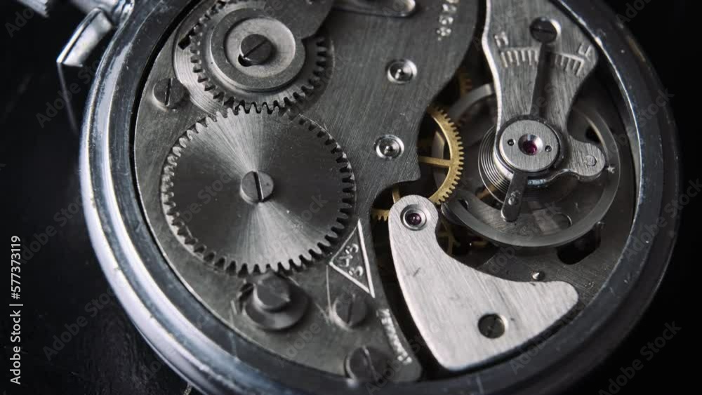 The mechanism of vintage stopwatch rotates closeup. Round clock watch