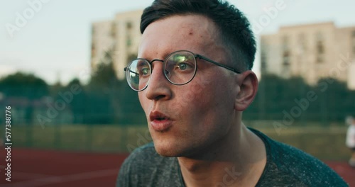 Young handsome concentrated basketball player tried to make slam dunk plays basketball with friends. Competition time outside with friends compani. Friendship concept. photo