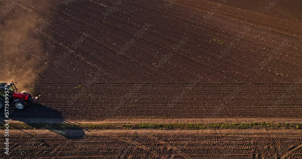 Farmer in tractor seeding soy beans at industrial agricultural farm