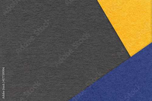 Texture of craft black color paper background with yellow and navy blue border. Vintage abstract cardboard.