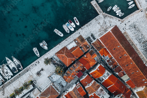 This stunning drone shot offers a bird's-eye view of Hvar's picturesque town nestled against the turquoise waters of the Adriatic Sea. The town's distinctive red rooftops create a beautiful contrast.