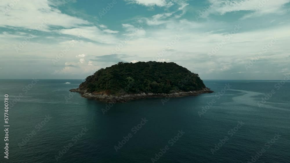Flying above a wild tropical island surrounded by deep blue sea. A cloudy horizon and a color grading conveys a dramatic atmosphere in the footage. Flying above a wild tropical island surrounded by deep blue sea. A cloudy horizon and a color grading conveys a dramatic atmosphere in the footage.