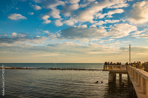 February 12  2023 - Ostia  Rome  Italy. The sea of Ostia  on the Roman coast  on a winter Sunday. People enjoy the holiday walking on the pier in the open air in the evening.