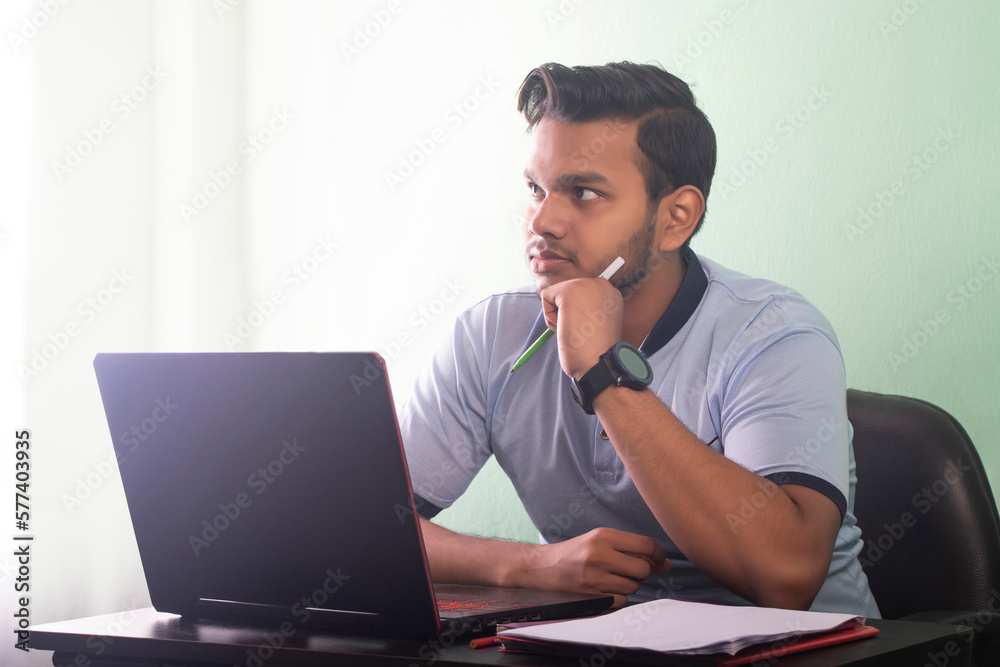 College student talking on a video call while writing his assignment College student talking on a video call while writing his assignment