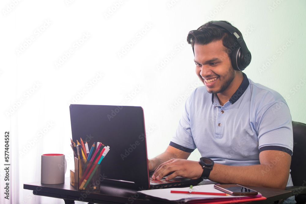 Man wearing headphones and using laptop Man wearing headphones and using laptop