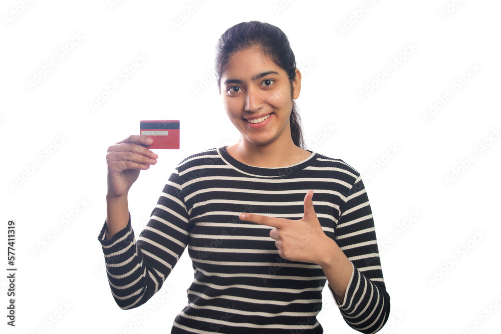 Portrait of a young woman pointing at credit card against white background Portrait of a young woman pointing at credit card against white background