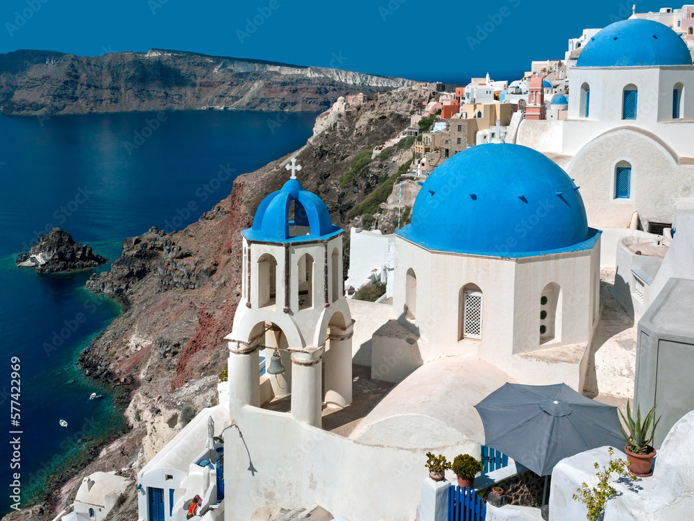 Fototapeta premium Bell Tower and Blue domed church high on the edge of the volcanic caldera on the Greek island of Santorini (Thira) in the southern Aegean Sea.