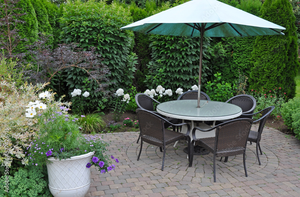 Patio table and umbrella in summer garden