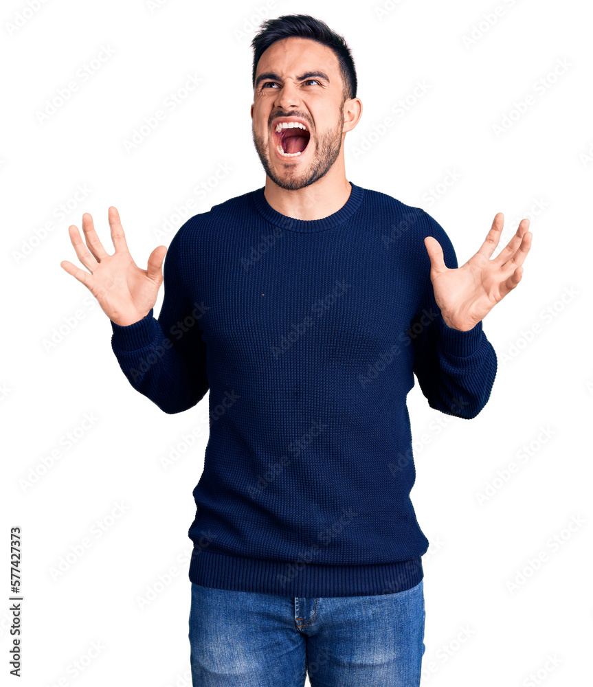 Fototapeta premium Young handsome man wearing casual clothes crazy and mad shouting and yelling with aggressive expression and arms raised. frustration concept.