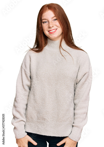 Young read head woman wearing casual winter sweater looking positive and happy standing and smiling with a confident smile showing teeth