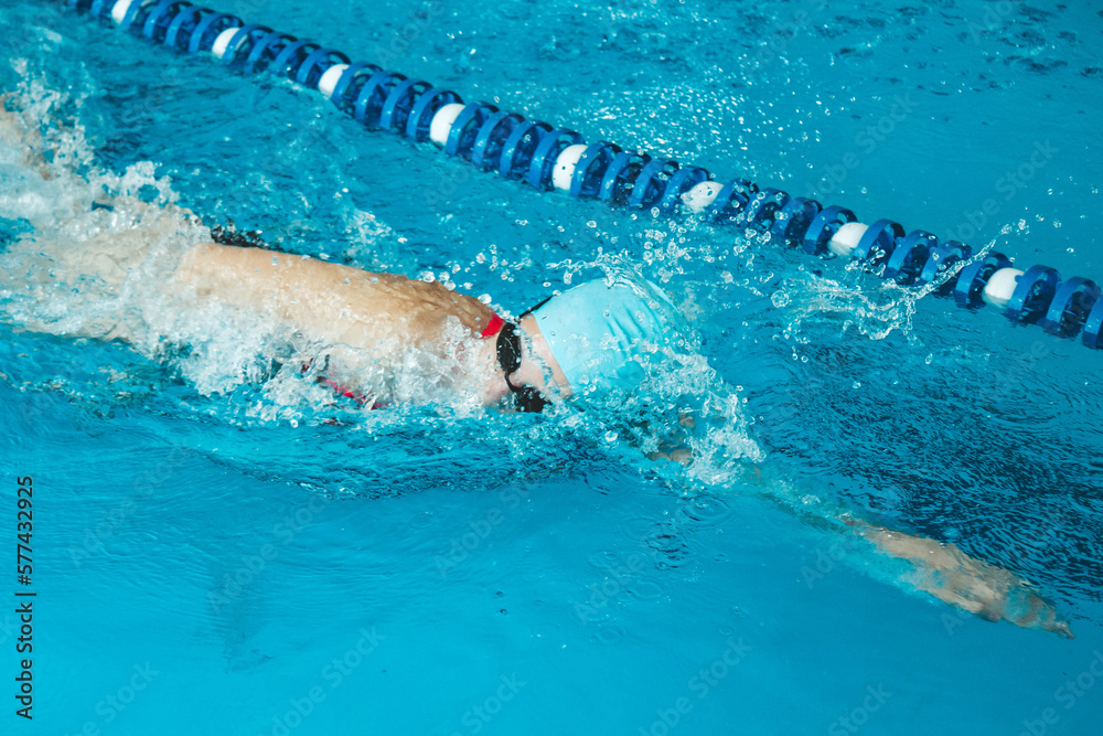 Beautiful female swimmer using front bypass, freestyle in the pool. Preparing professional athletes to win the championship.