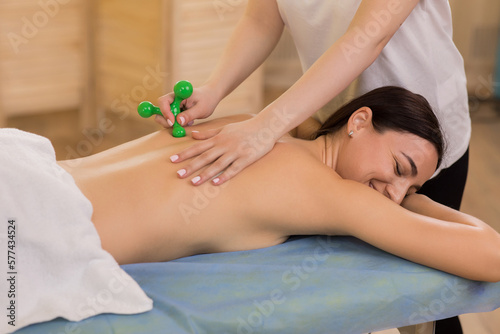 Foto Professional massage room the therapist woman using special massage accessories