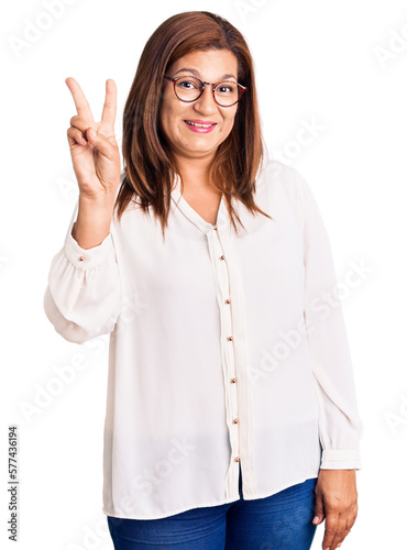 Middle age latin woman wearing casual clothes and glasses showing and pointing up with fingers number two while smiling confident and happy.