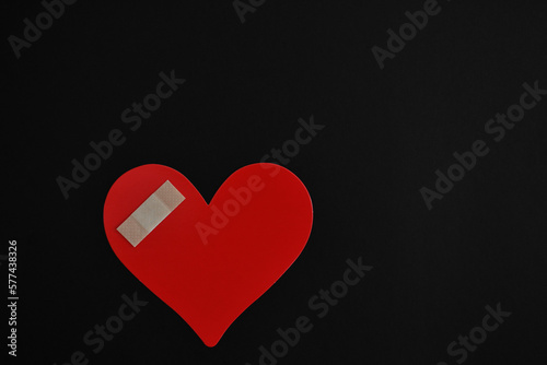 Corazón lastimado sobre fondo negro, espacio para texto al lado derecho. photo